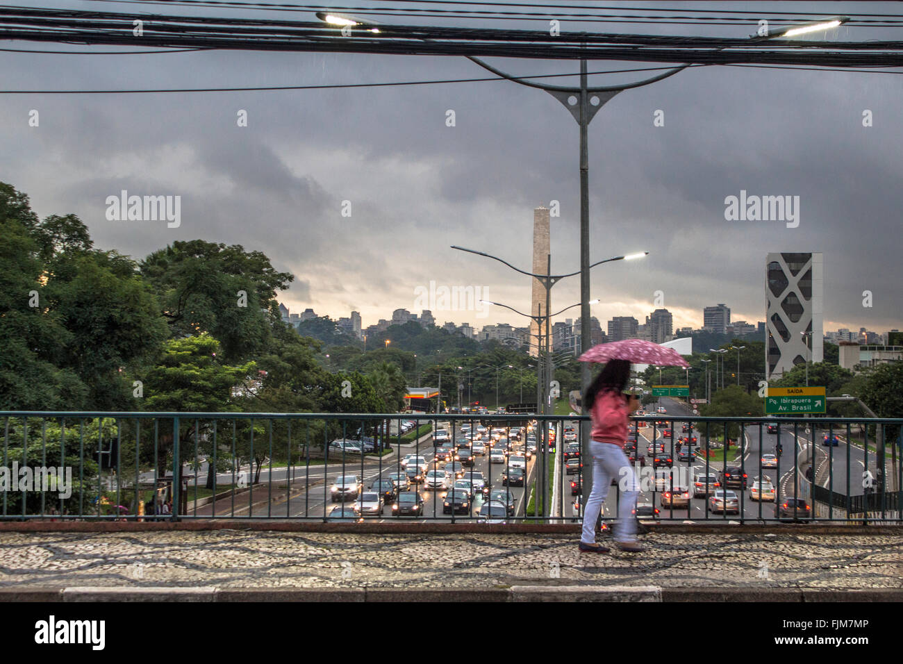 São Paulo, SP, Brazil, March 03, 2016 Woman walk on catwalk and traffic in 23 de Maio Avenue at sunrise with rain in São Paulo SP, on Thursday (3). The sky over various regions of the capital is with thunderclouds Credit:  Alf Ribeiro/Alamy Live News Stock Photo