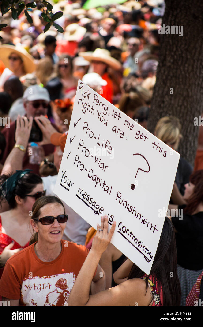 A women questions former Texas governor Rick Perry's motives with this sign showing his inconsistency in legislation on abortion Stock Photo