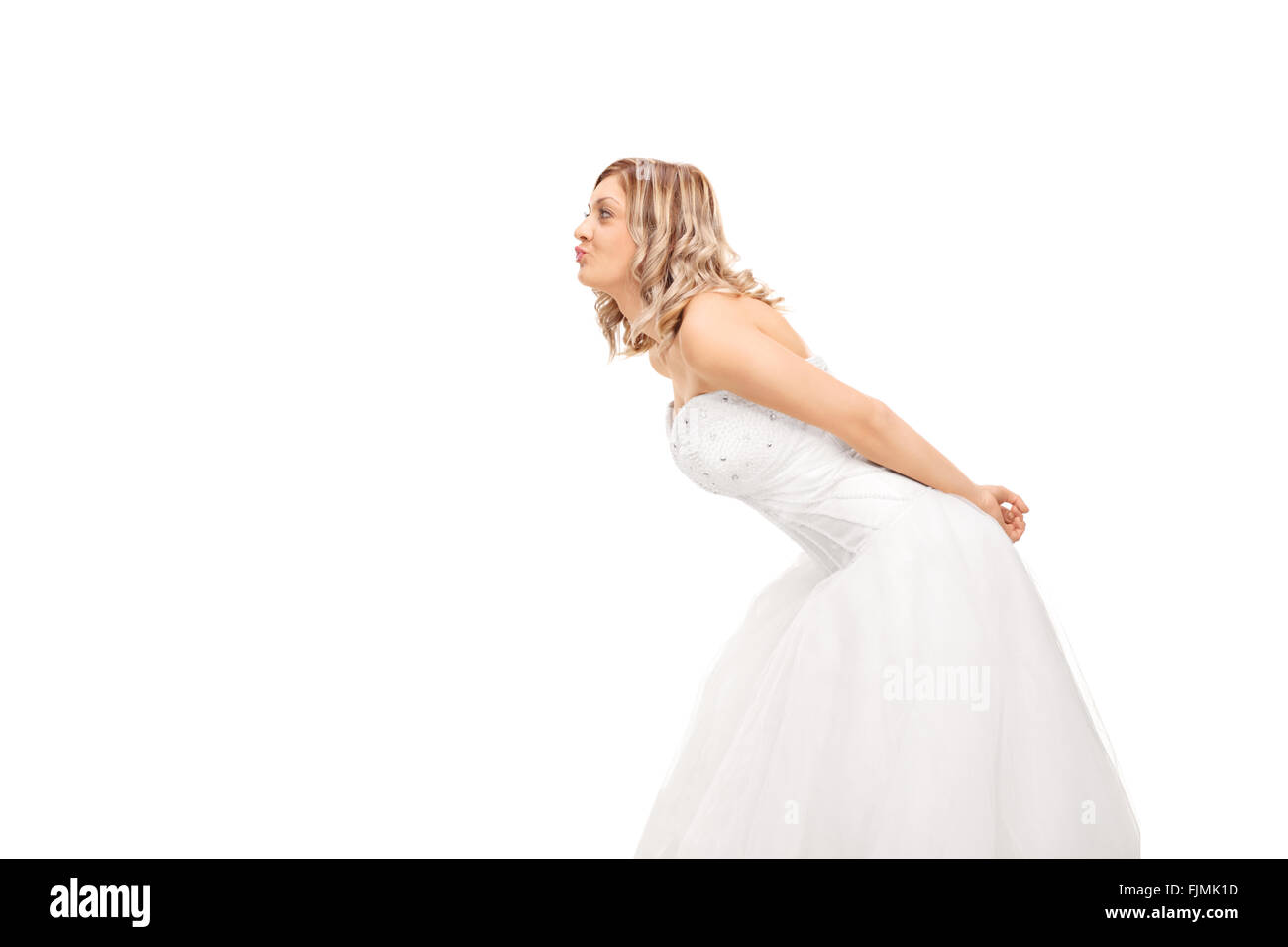 Profile shot of a young blond bride leaning to kiss someone isolated on white background Stock Photo