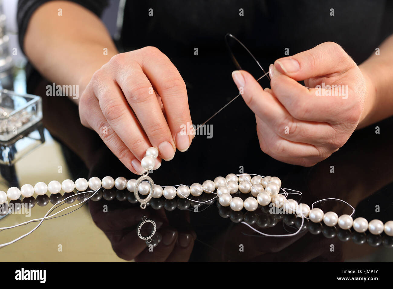 Workshop jewelery, creating jewelry with pearls. Pearls, beads. Threading beads Pearl necklace Stock Photo