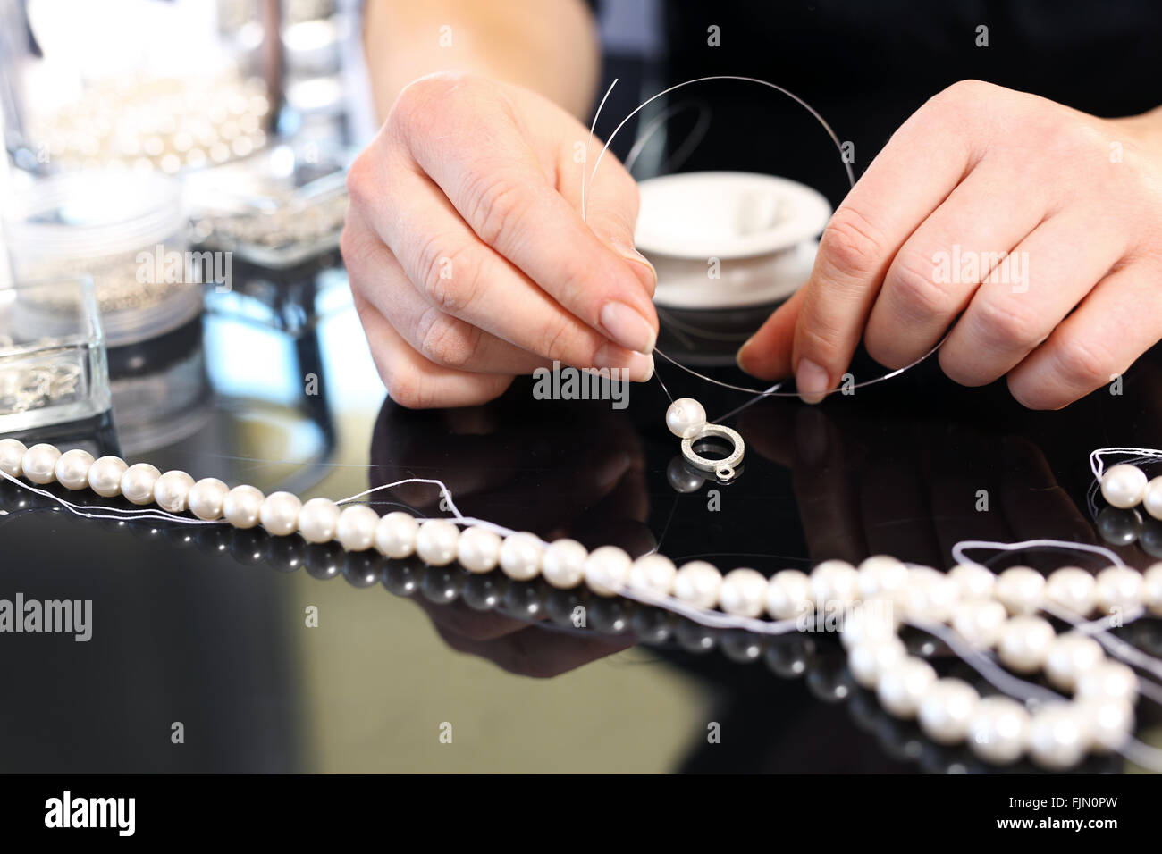 Workshop jewelery, creating jewelry with pearls. Pearls, beads. Threading beads Pearl necklace Stock Photo