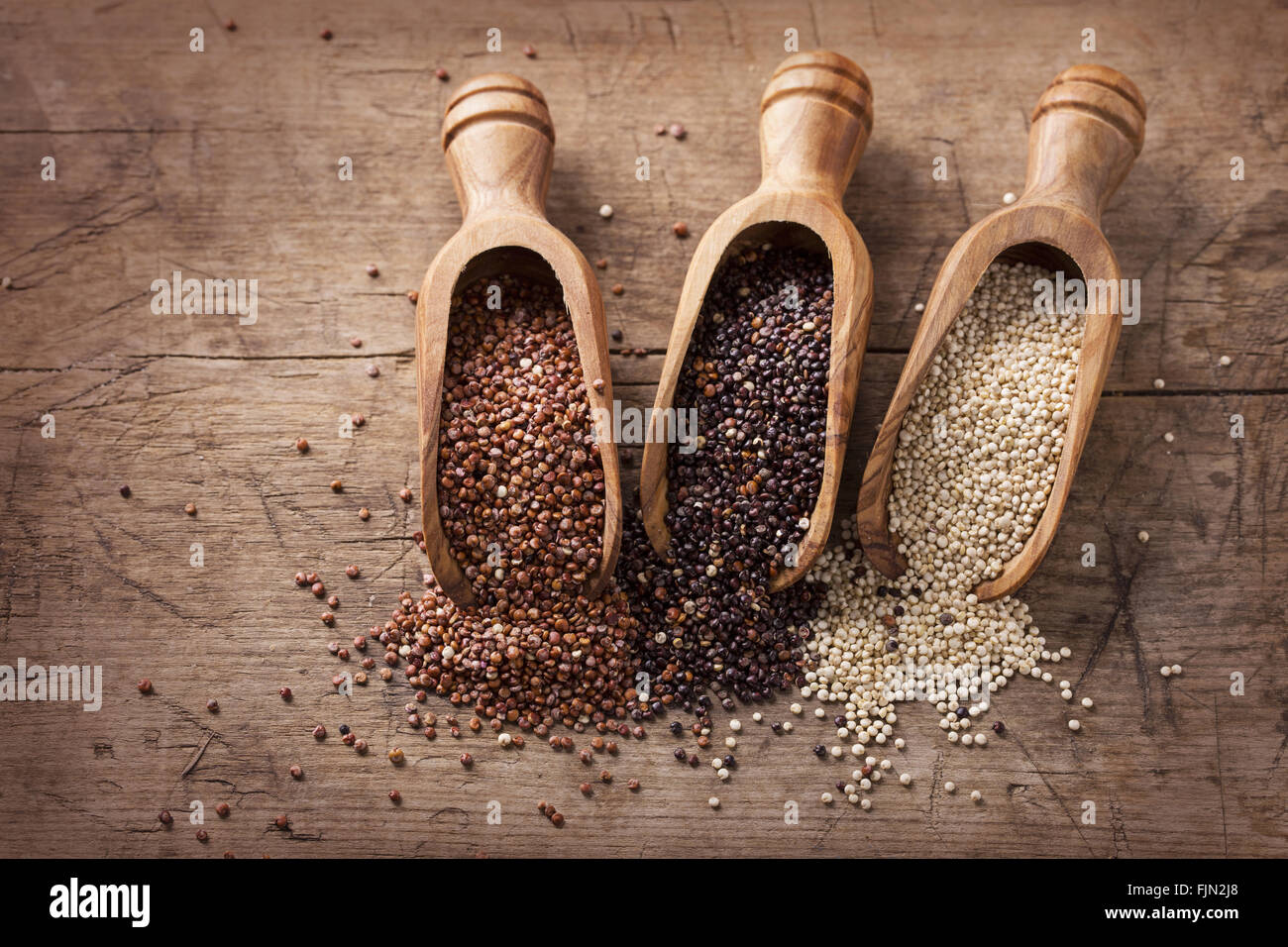 Red, black and white quinoa seeds on a wooden background Stock Photo