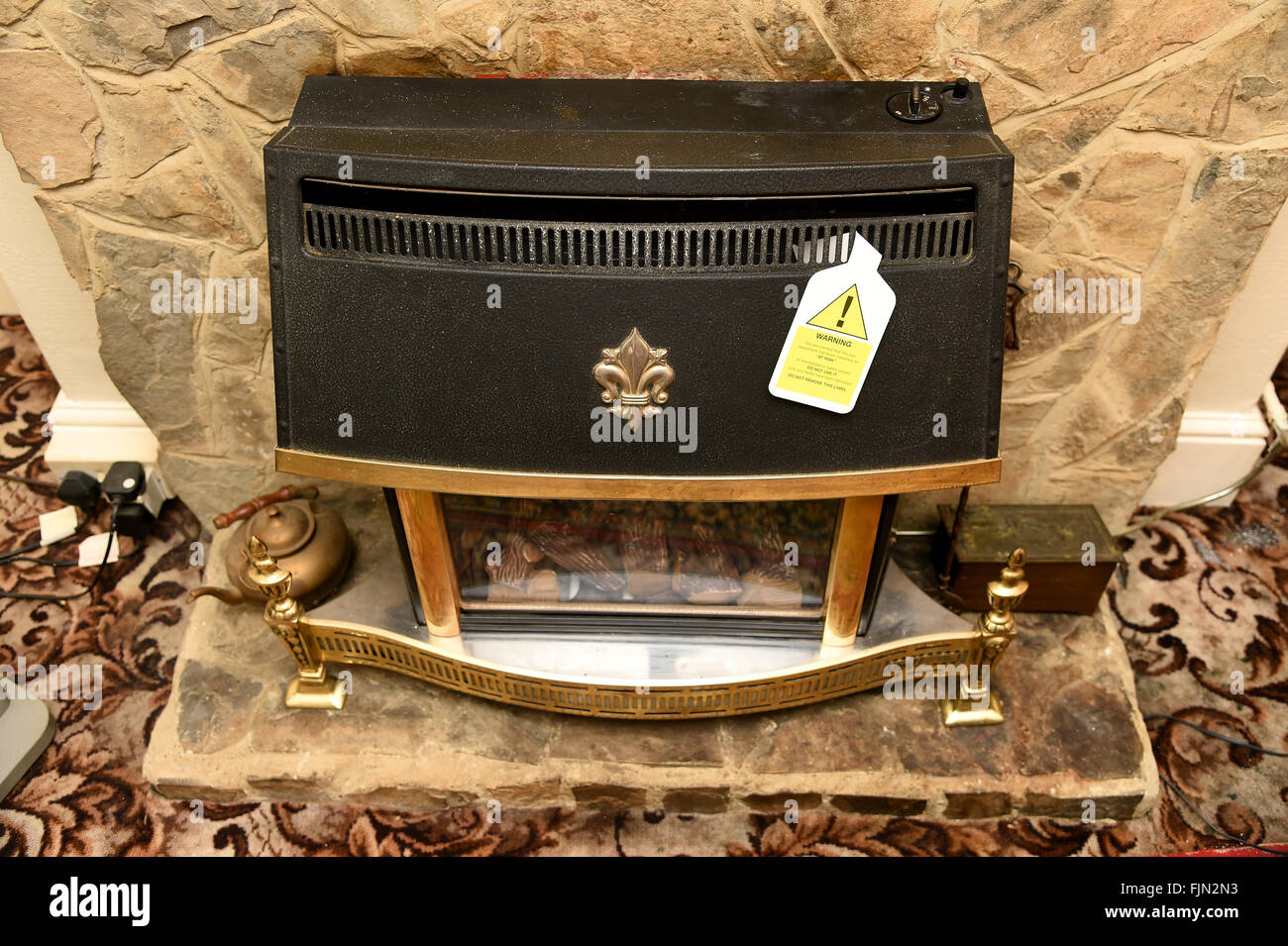 Unsafe gas fire, fireplace with warning sign, UK Stock Photo Alamy