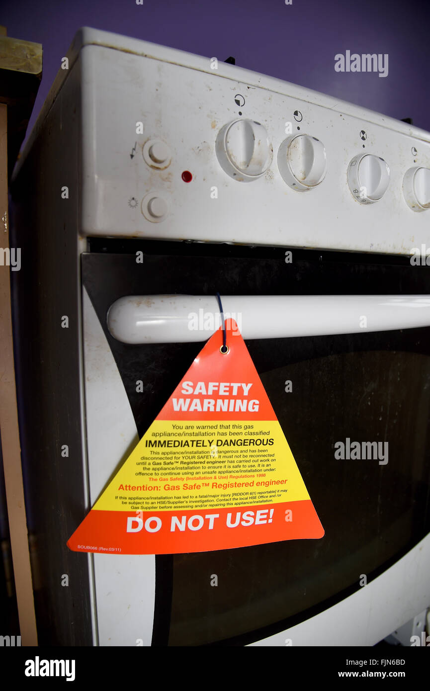 Unsafe gas cooker with safety warning notice, UK Stock Photo