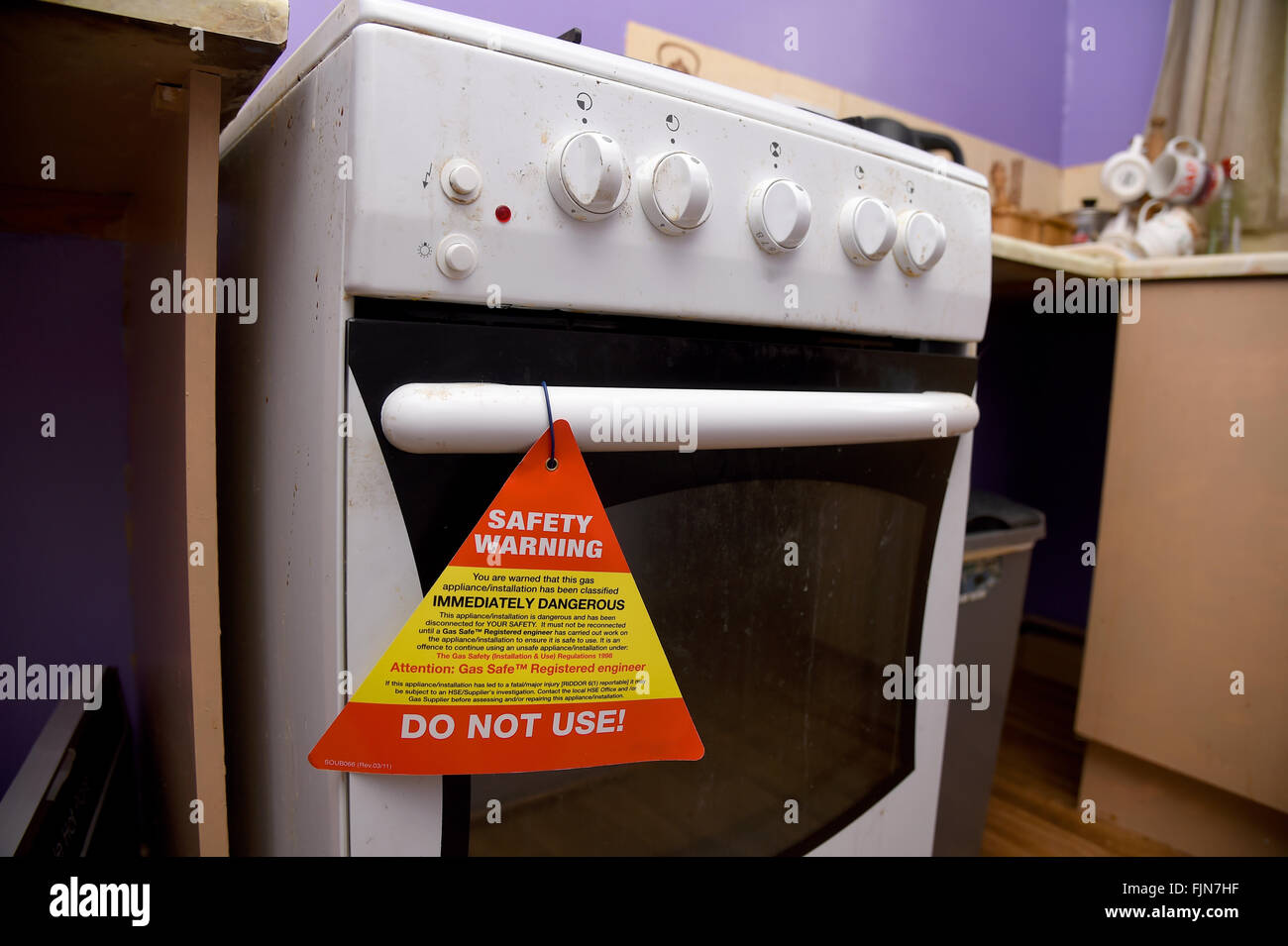 Unsafe gas cooker with safety warning notice, UK Stock Photo