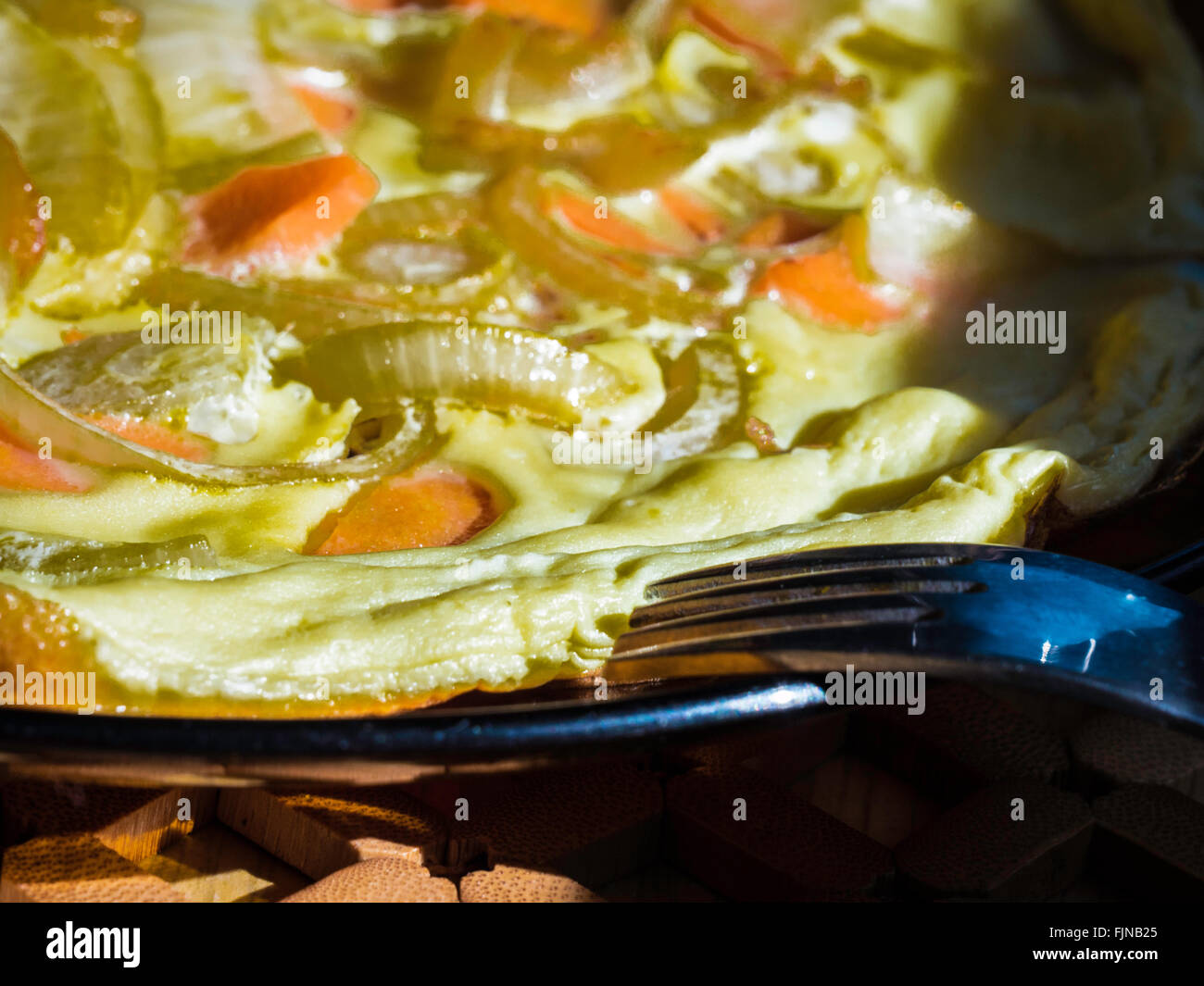 Close-Up Of Cooked Dish With Onion Ready To Eat, Metal Fork In Foreground Stock Photo