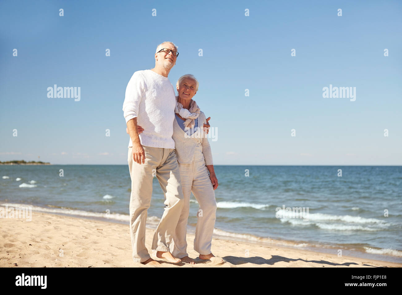 Old couple walking along beach hi-res stock photography and images - Alamy