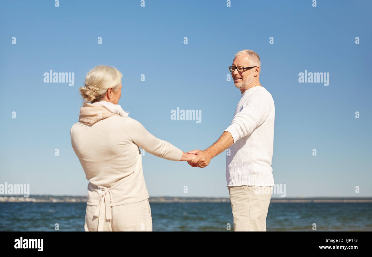 happy senior couple holding hands summer beach Stock Photo - Alamy