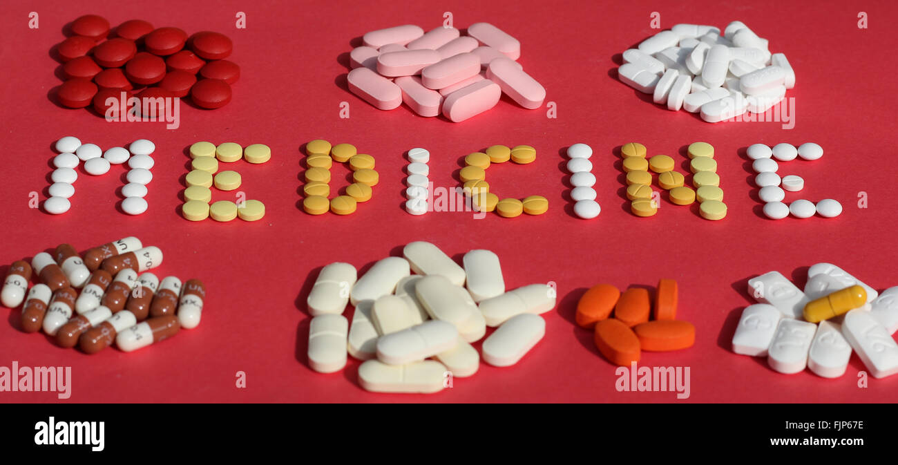 Capsules and pills on red background Stock Photo