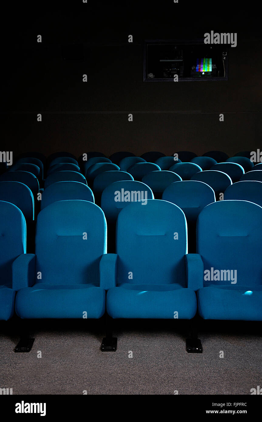 Cinema seats in a movie theater and projector in the background Stock Photo  - Alamy