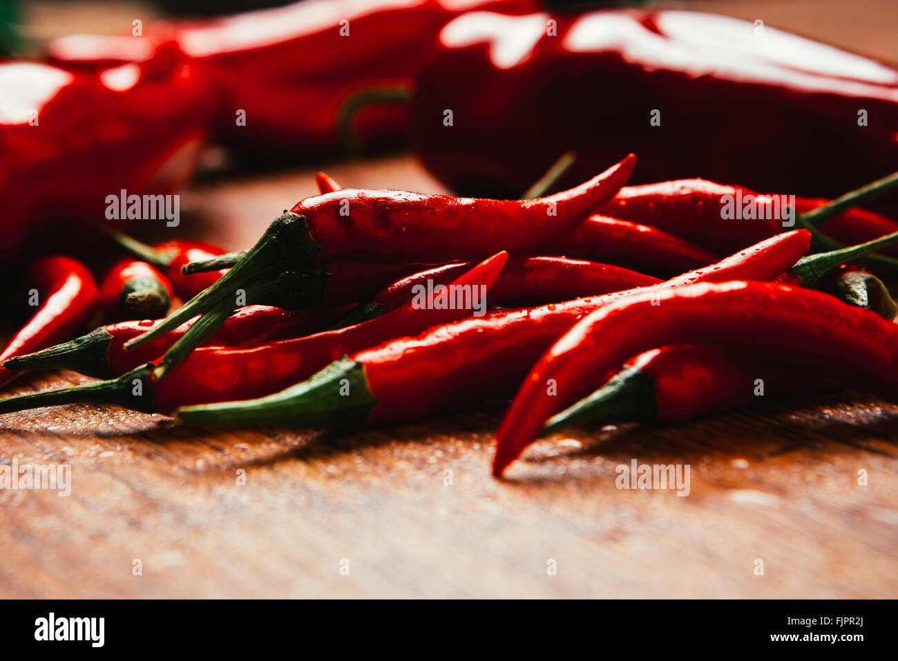 red and green chili peppers close up on wooden background Stock Photo ...