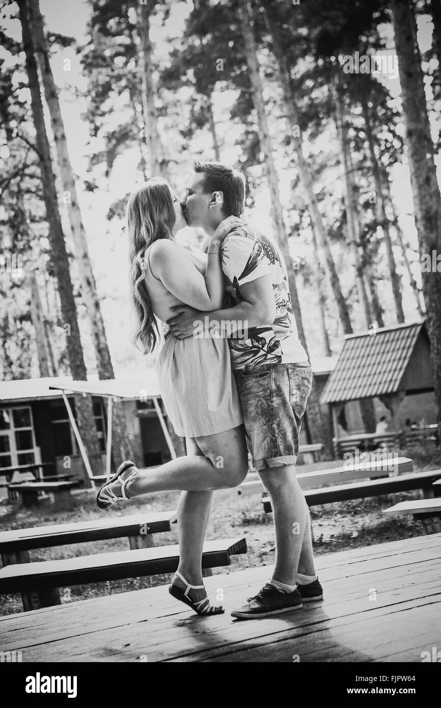 Black white photography romantic young couple kissing on background summer forest