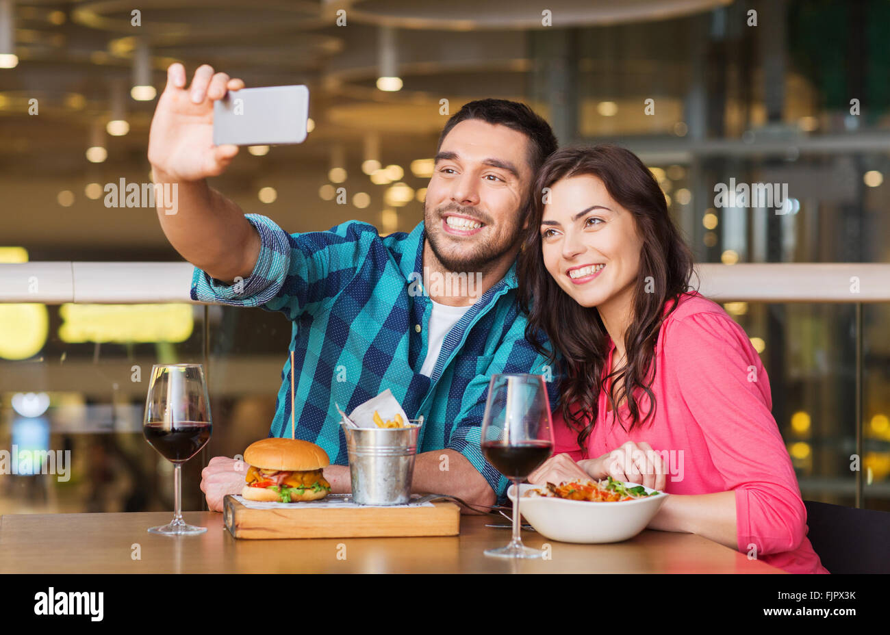couple taking selfie by smartphone at restaurant Stock Photo