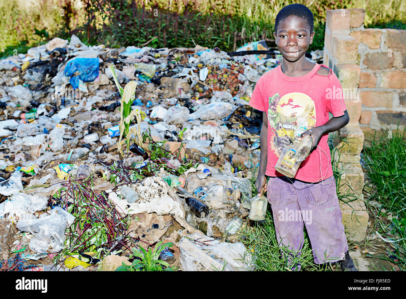 Small boy collecting trash at a garbage dump in Manyama, Zambia. Stock Photo
