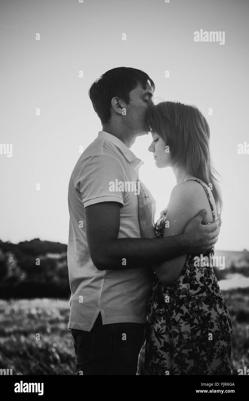 Black white photography romantic couple standing and kissing on