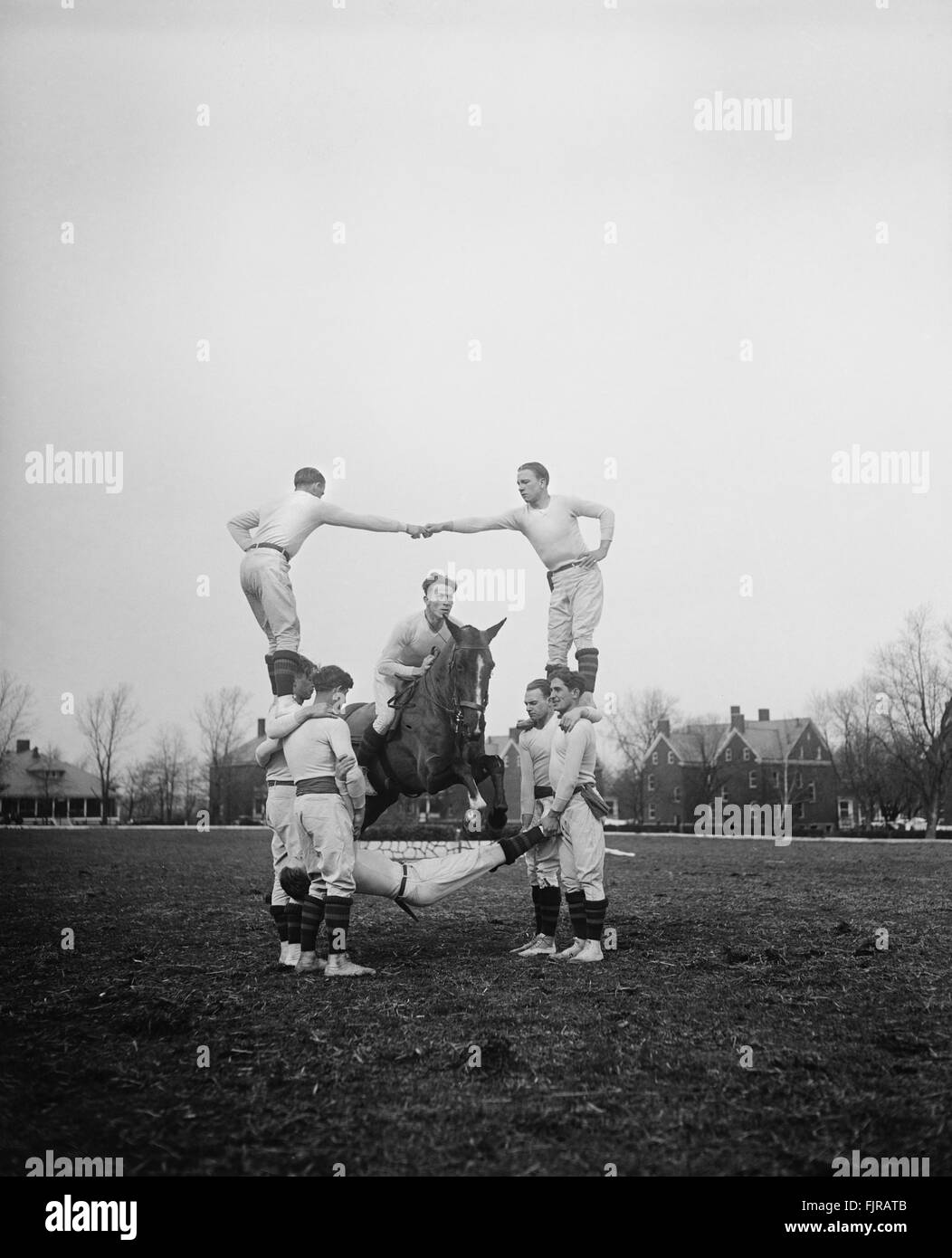 Man on Horse Jumping Through Pyramid of Acrobatic Men, circa 1931 Stock Photo