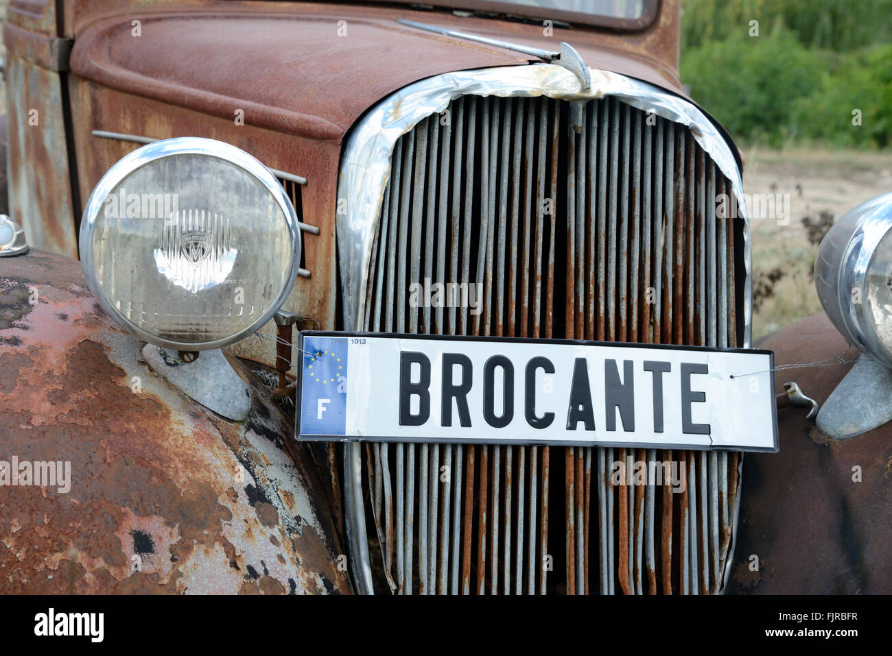 Brocante Sign and Old Rusty Vintage Renault Car or Automobile Stock Photo