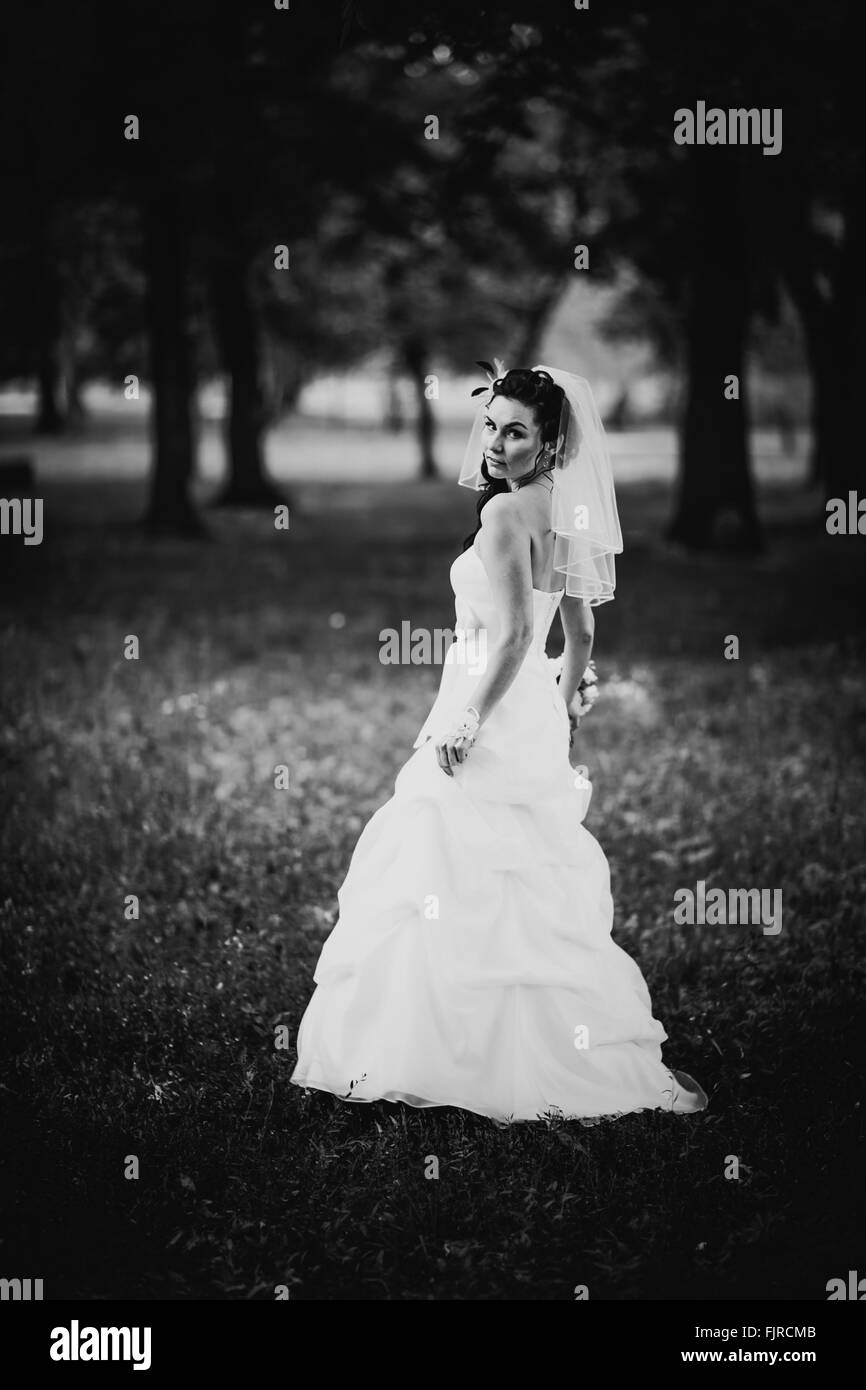 Black white photography beautiful young bride stand on  background forest Stock Photo