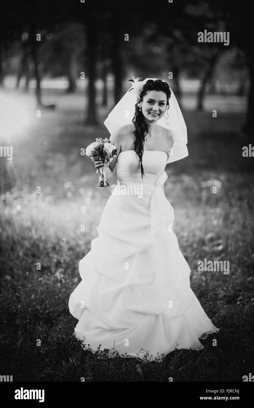 Black white photography beautiful young bride stand on  background forest Stock Photo