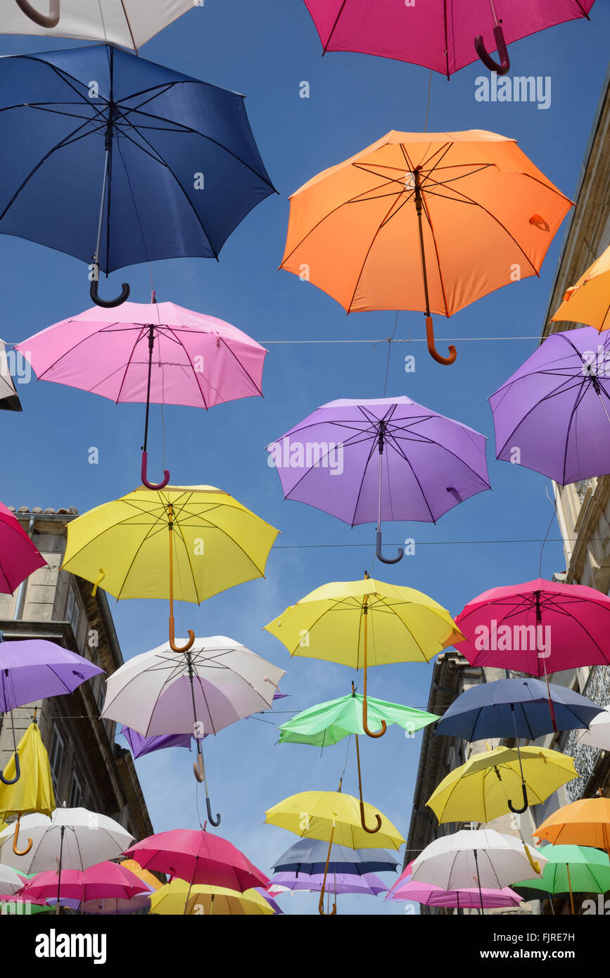 Display of Colourful Umbrellas Silhouetted Against Blue Sky. Street Art or Installation Art in Streets of Arles, Provence, France Stock Photo