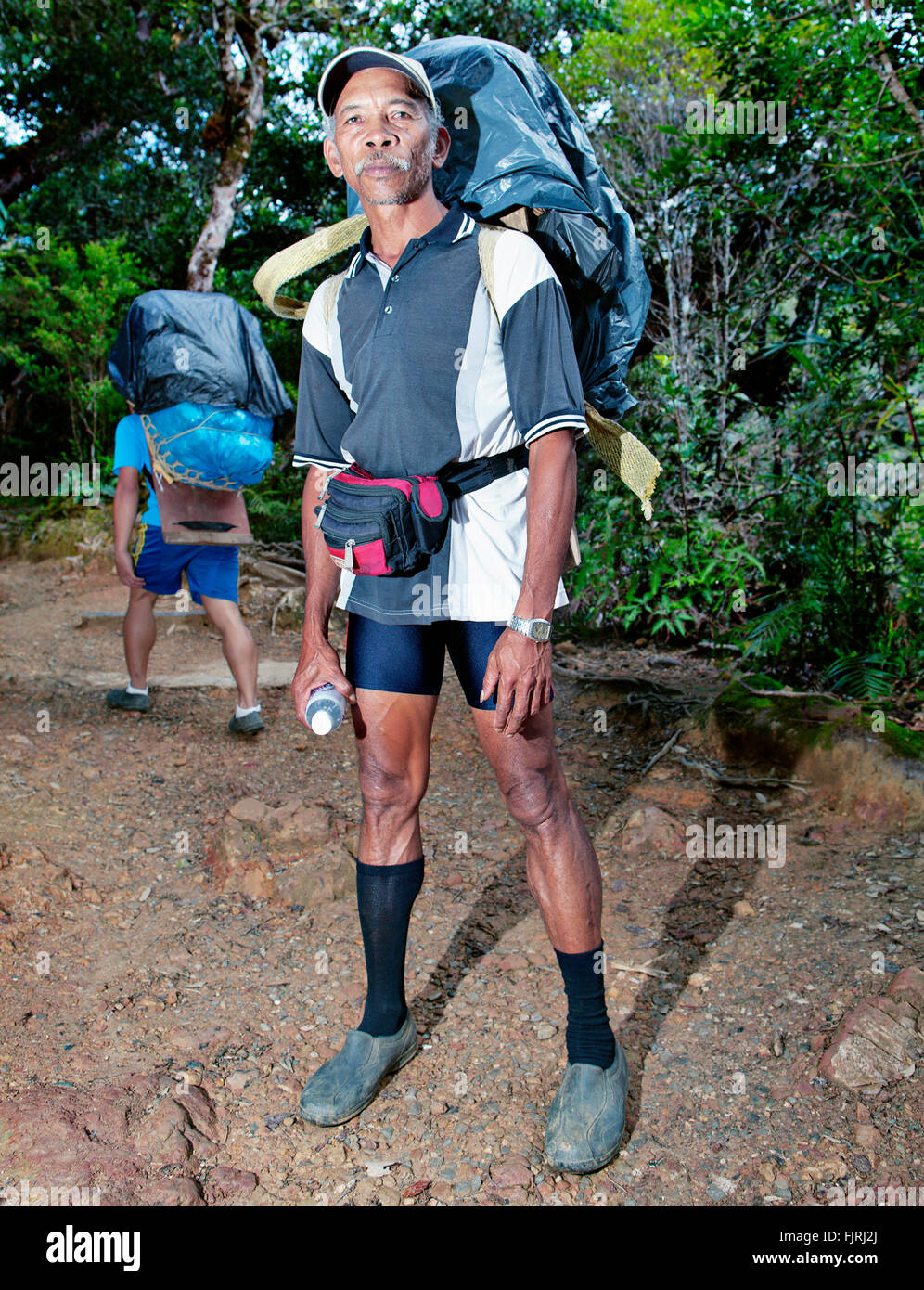 Porters on a trekking path to Mount Kinabalu, the highest mountain of Borneo. Stock Photo