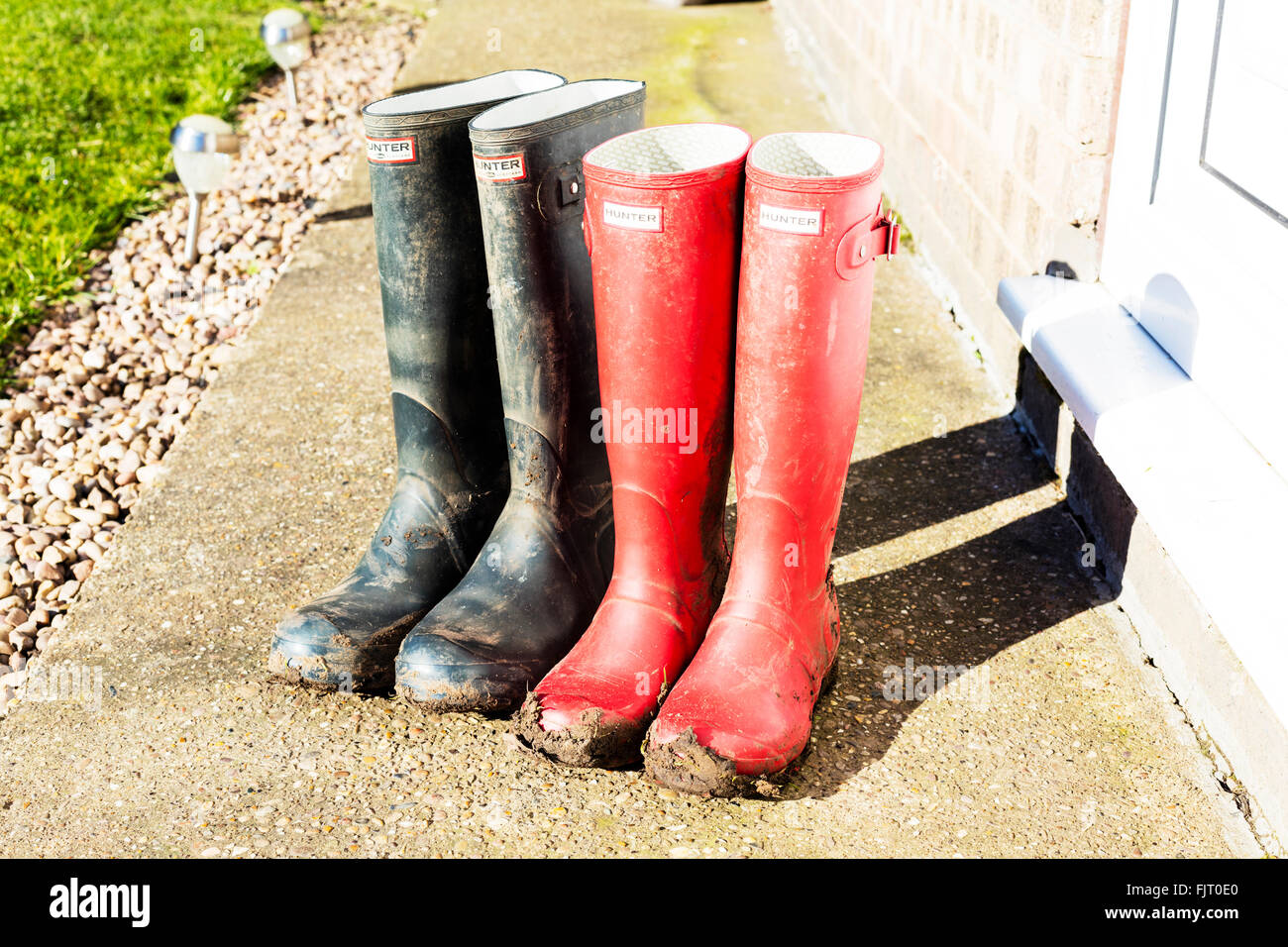 Muddy boots wellington wellingtons wellies outside mud walk Hunters make brand Stock Photo