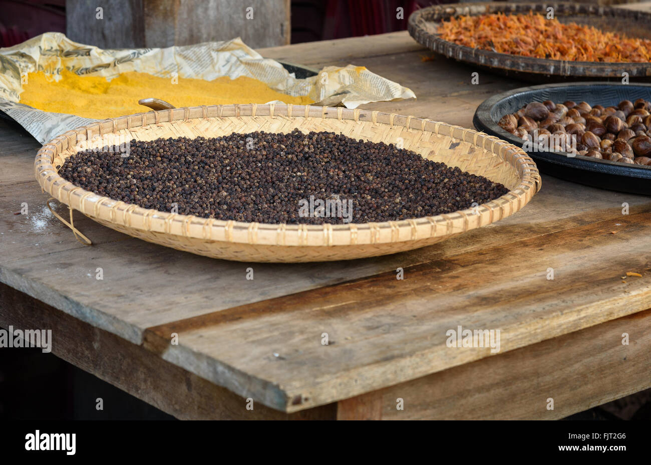 Black pepper drying in the sun on the street in village Stock Photo