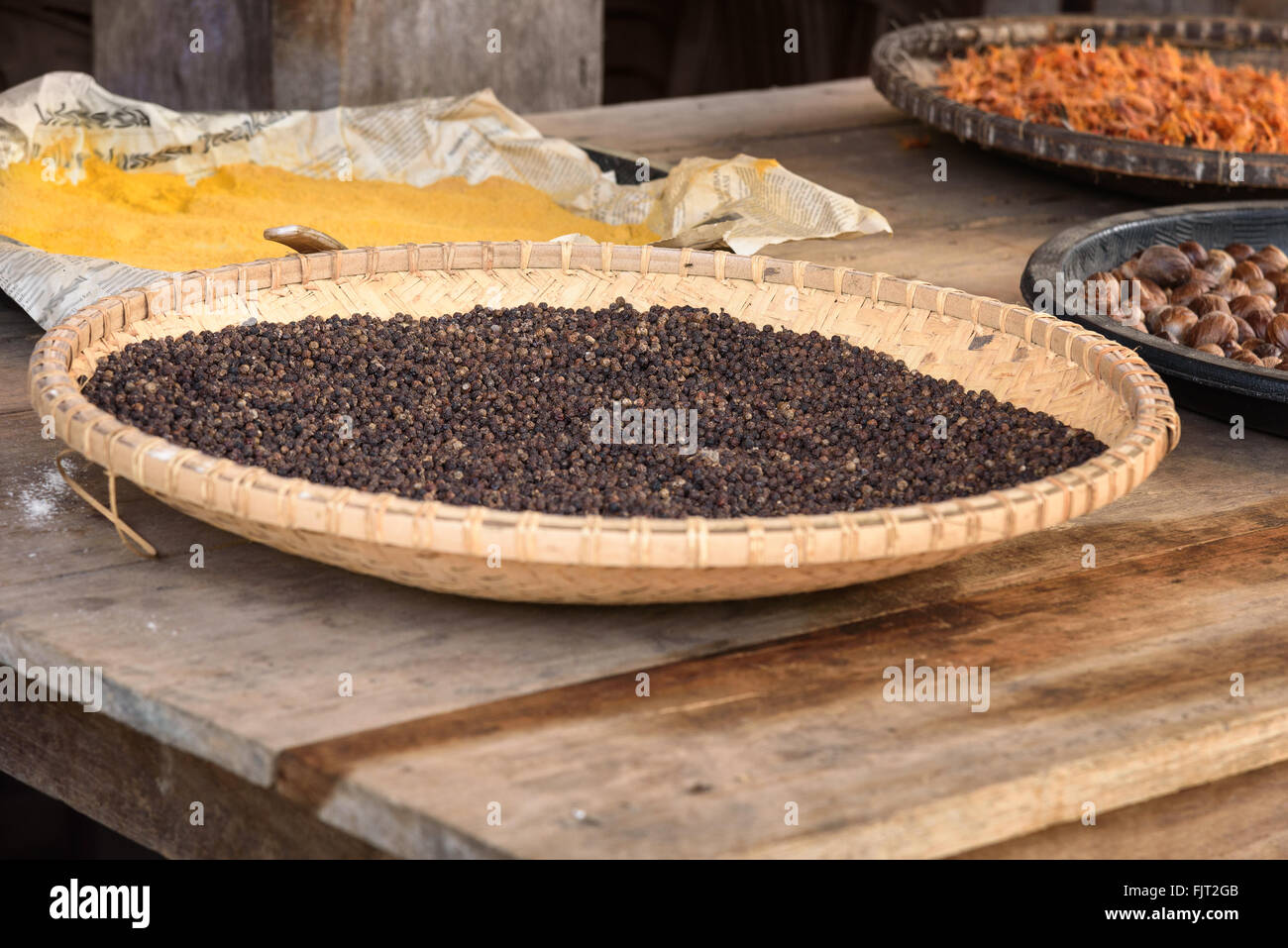 Black pepper drying in the sun on the street in village Stock Photo