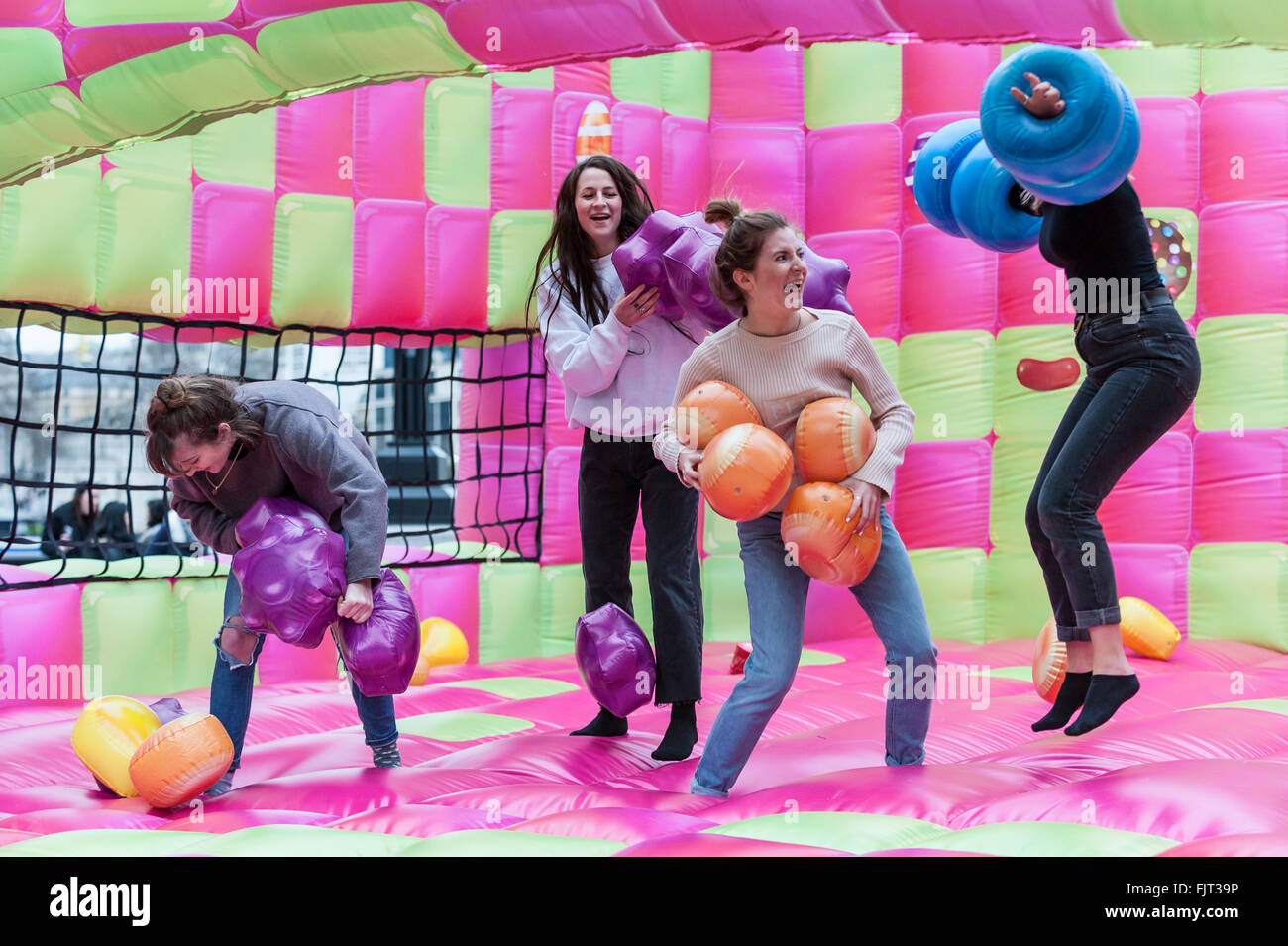 London, UK.  3 March 2016.  Members of the public enjoy playing on a jelly-themed bouncy castle erected outside City Hall at More London.  Open to adults only, the three day event celebrates the launch of a new mobile-phone game called 'Candy Crush Jelly Saga'. Credit:  Stephen Chung / Alamy Live News Stock Photo