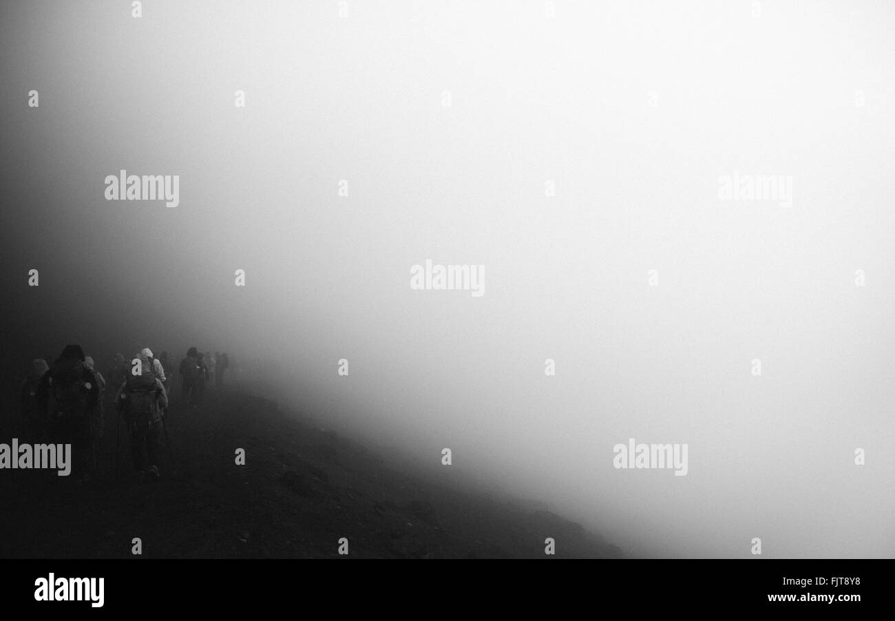 Rear View Of People Walking On Mountain In Foggy Weather Stock Photo ...