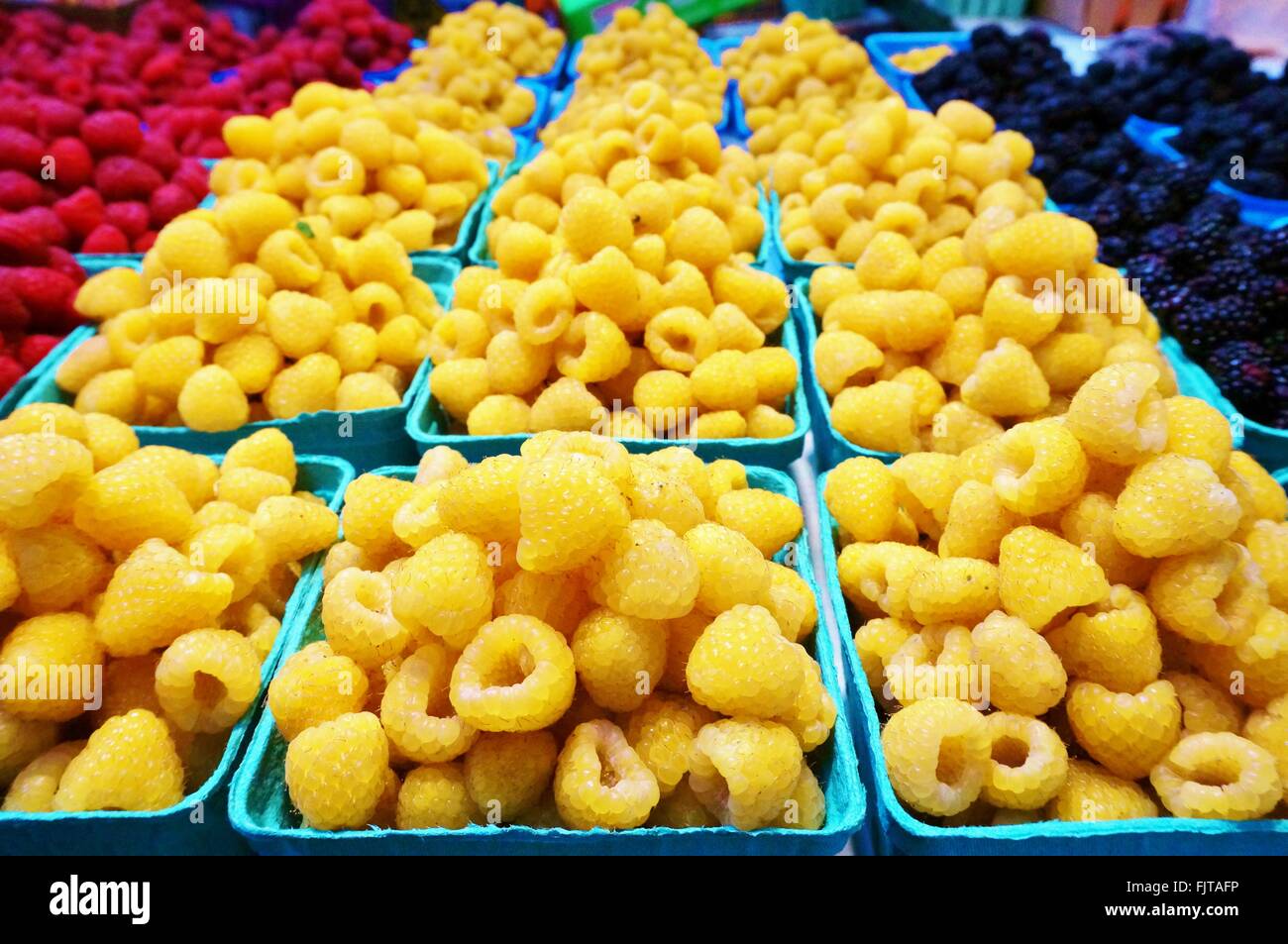 Golden yellow raspberries in containers at the market Stock Photo