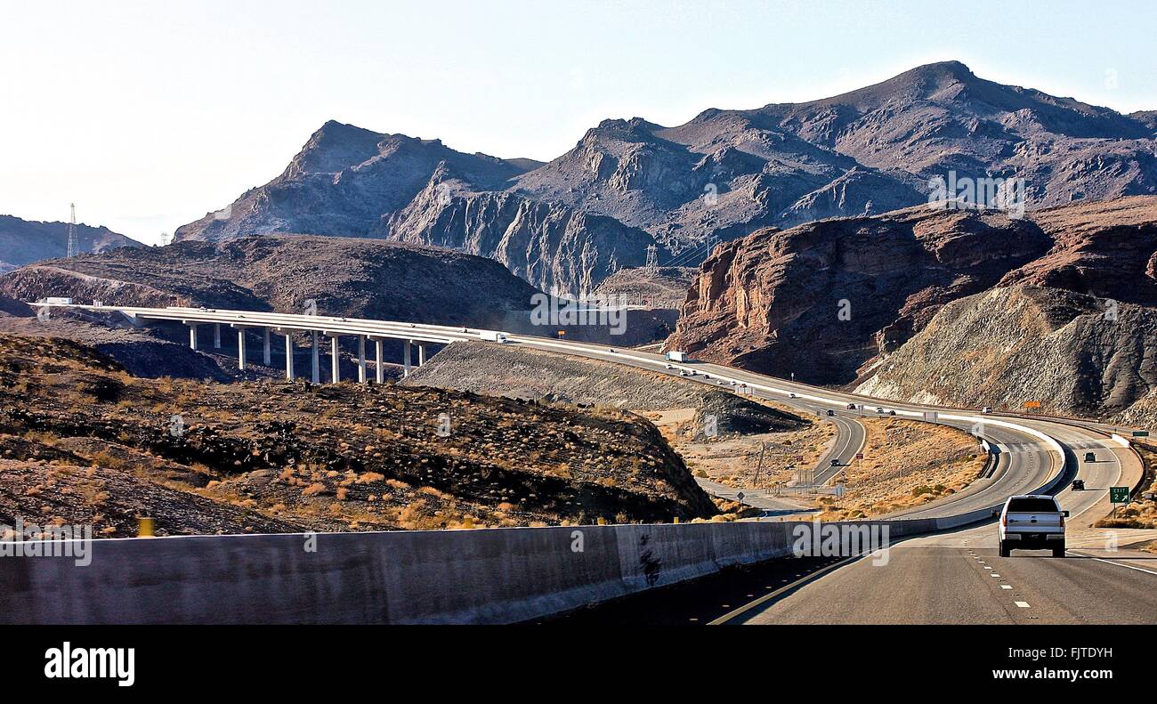 Scenic View Of Vehicles On Highway By Mountains Against Sky Stock Photo