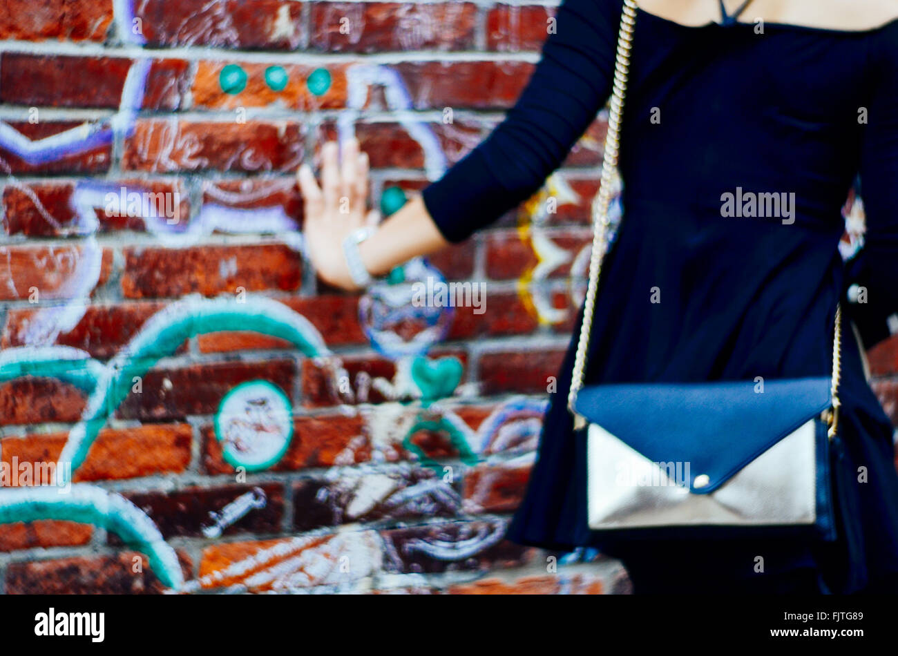Midsection Of Woman Touching Graffiti Wall Stock Photo