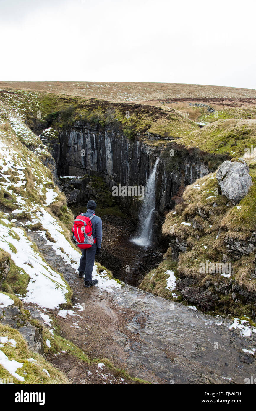 Walker looking down into Hull Pot Horton in Ribblesdale, North, Yorkshire, England. Stock Photo