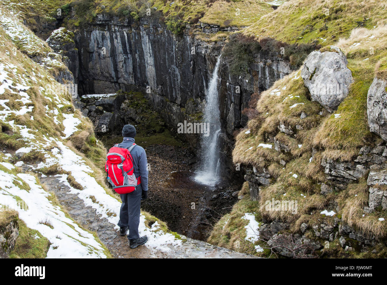 Walker looking down into Hull Pot Horton in Ribblesdale, North, Yorkshire, England. Stock Photo