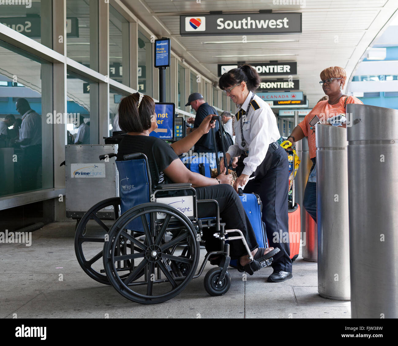 A Southwest Airline employee assists a passenger in a wheelchair at La  Guardia Airport in New York City Stock Photo - Alamy
