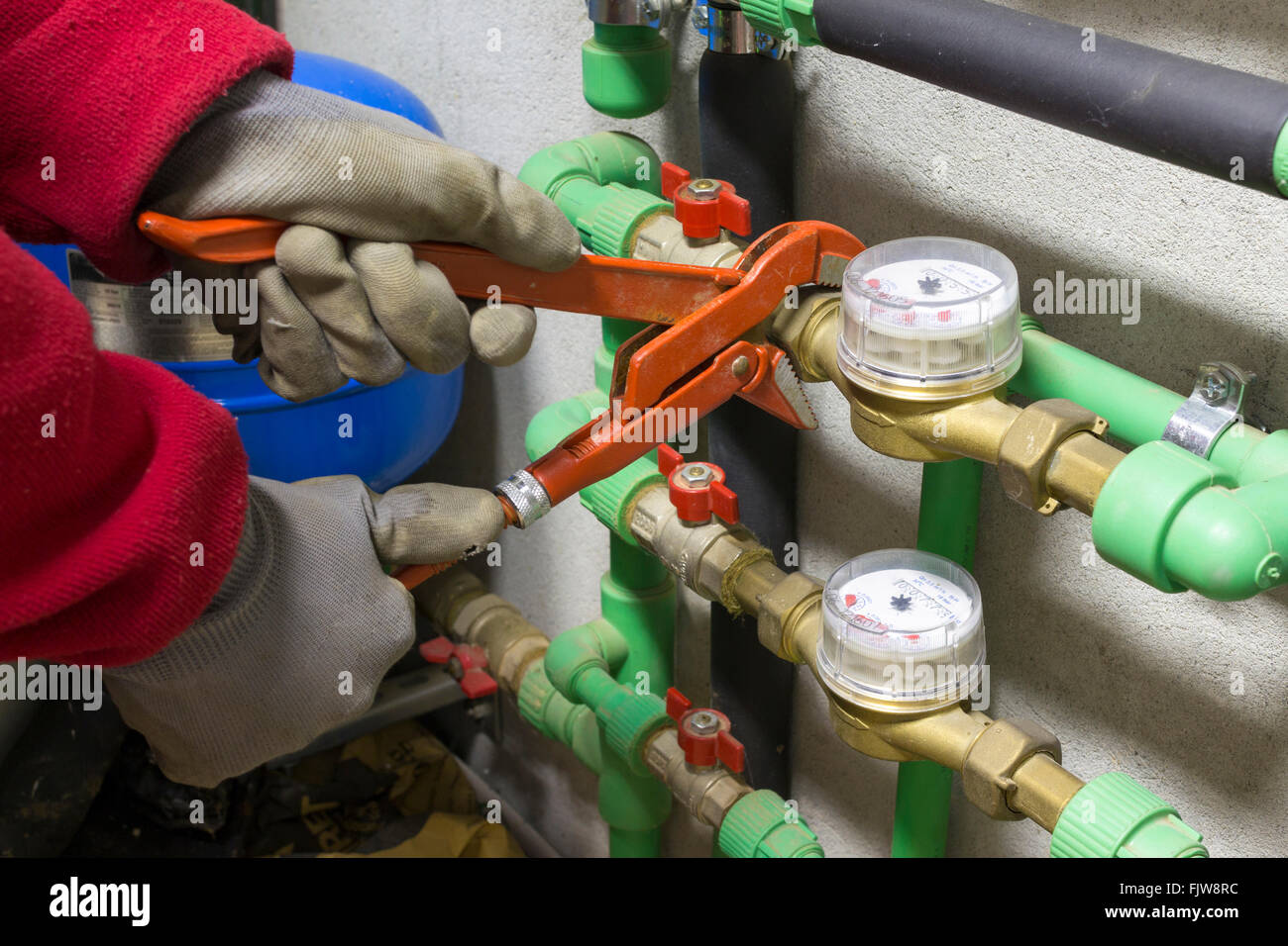 plumber at work installing a water meter Stock Photo