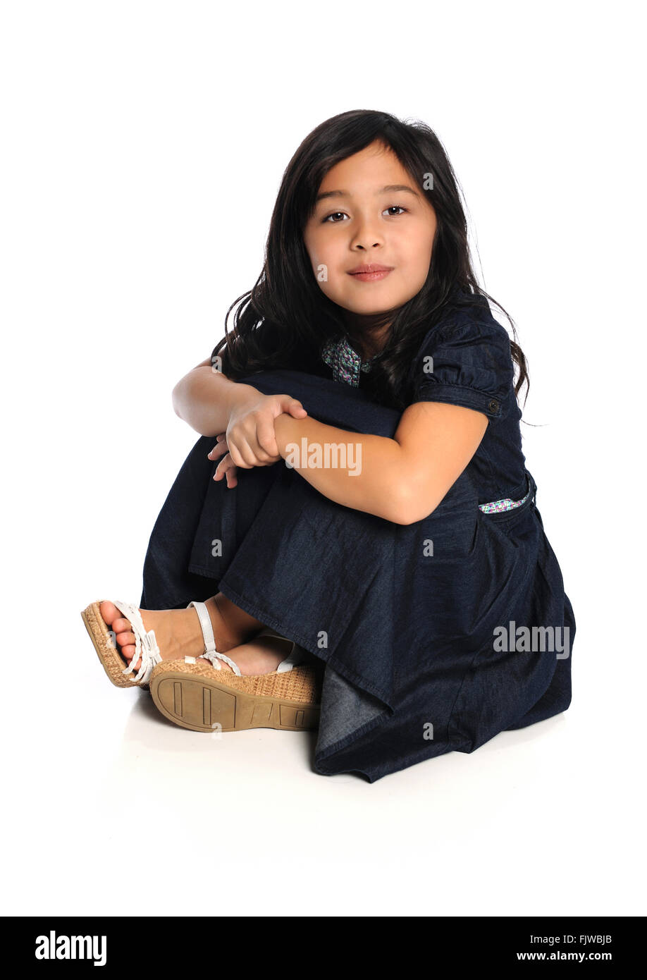 Portrait of cute Asian girl sitting isolated over white background Stock Photo