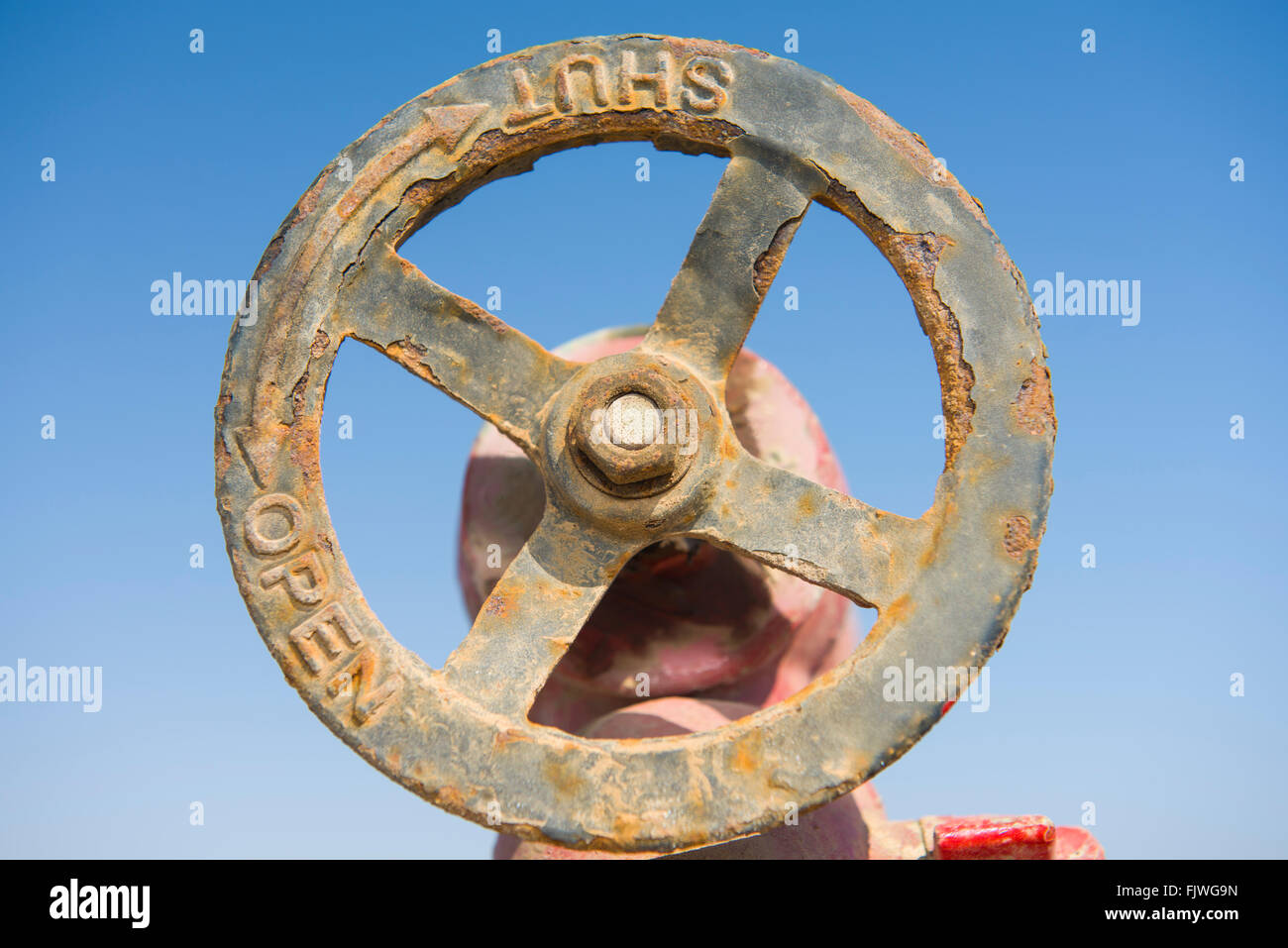 Old rusty circular hand wheel valve on a water pipe line Stock Photo