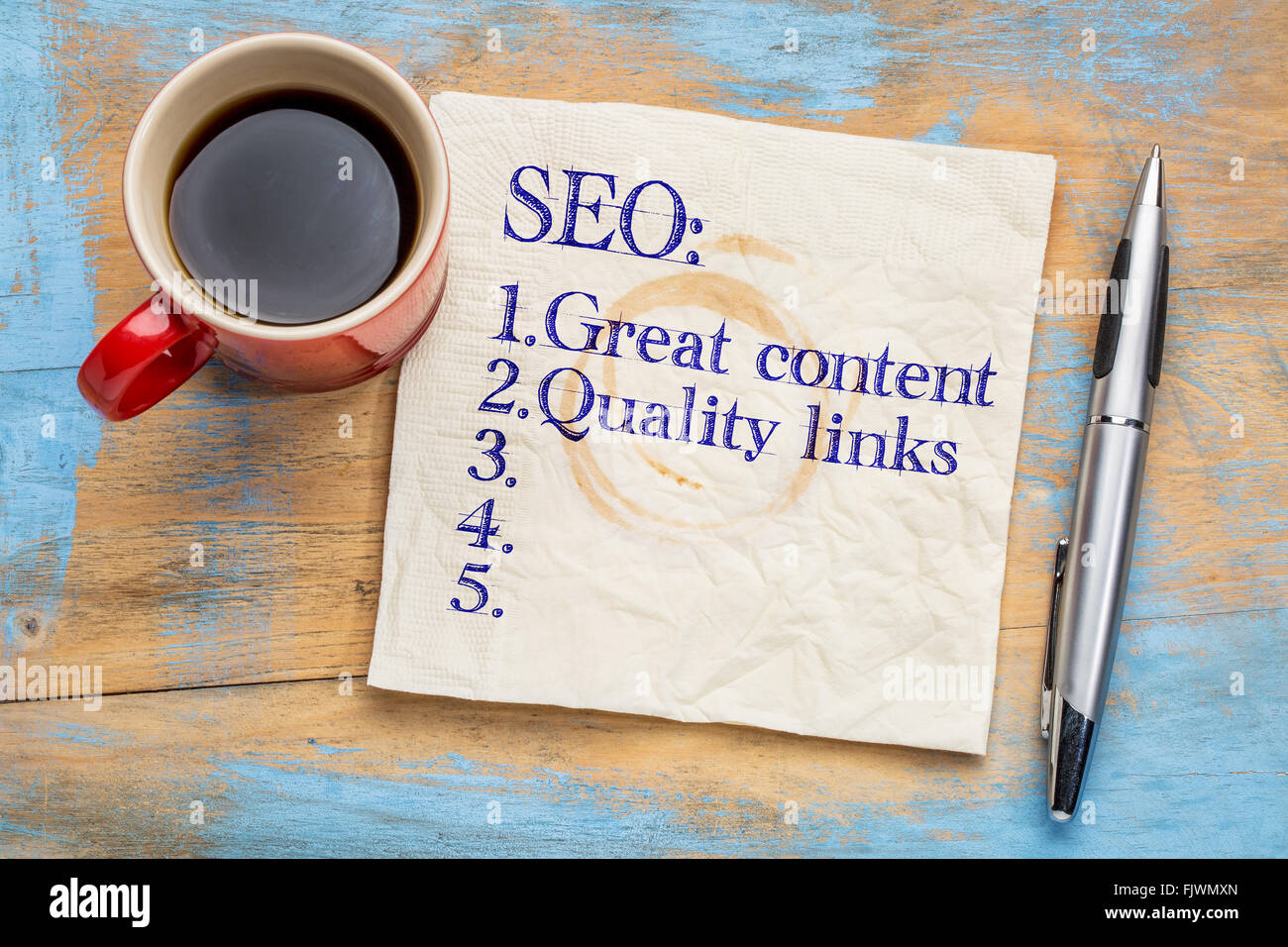 SEO (search engine optimization) tips (great content and quality links) on napkin with a cup of coffee Stock Photo