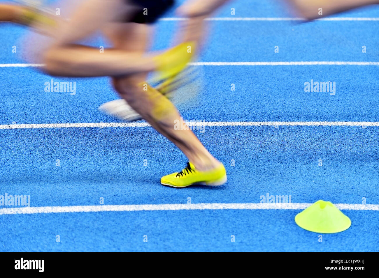 Blurred athletes by a slow camera shutter speed competing on blue