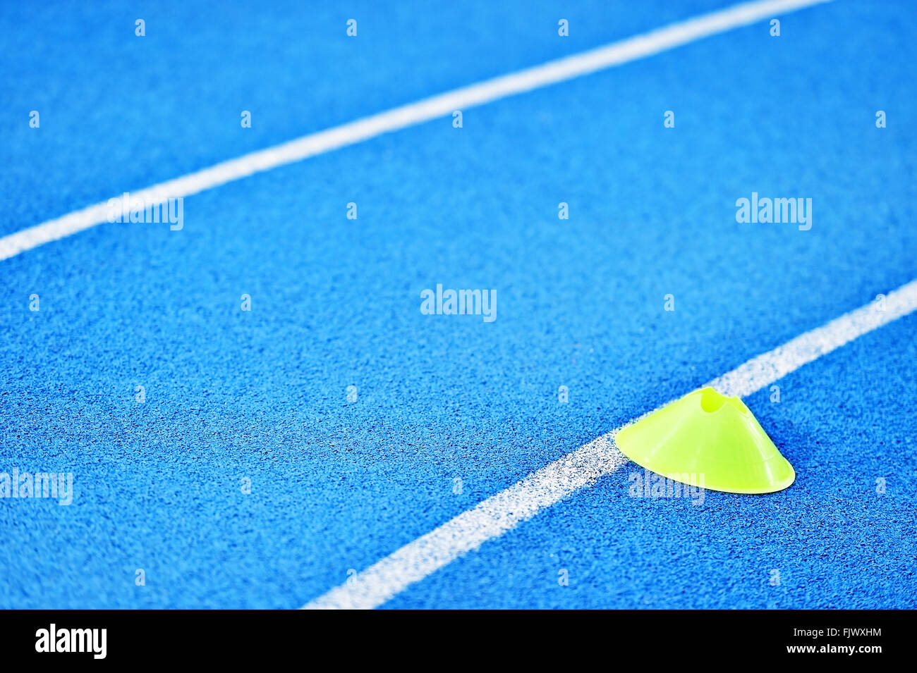 Athletics blue sprint track with yellow marker training cones Stock