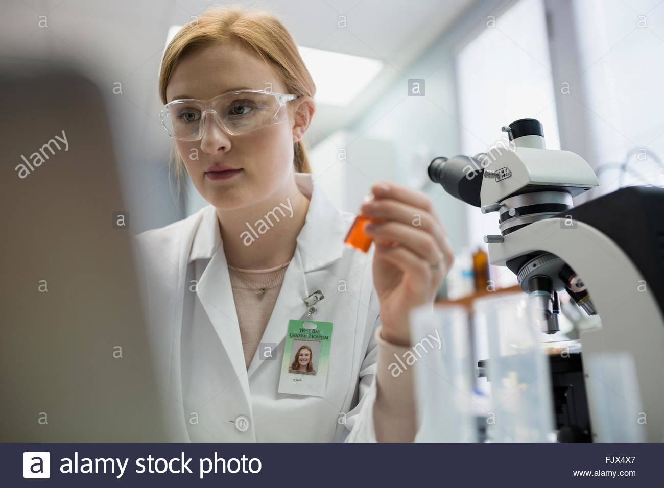 Medical scientist working at laptop near microscope laboratory Stock Photo Alamy