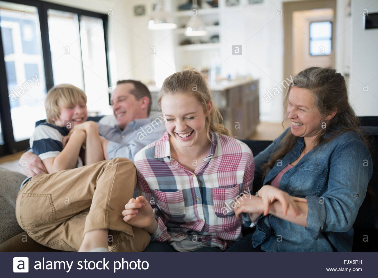 Laughing family on living room sofa Stock Photo