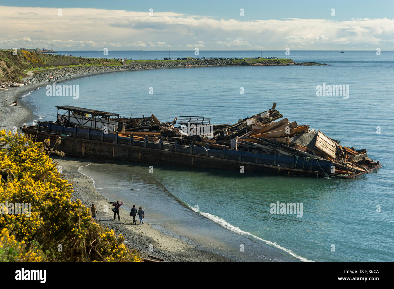 Beached stranded barge with load of junk at Clover Point beach-Victoria, British Columbia, Canada. Stock Photo