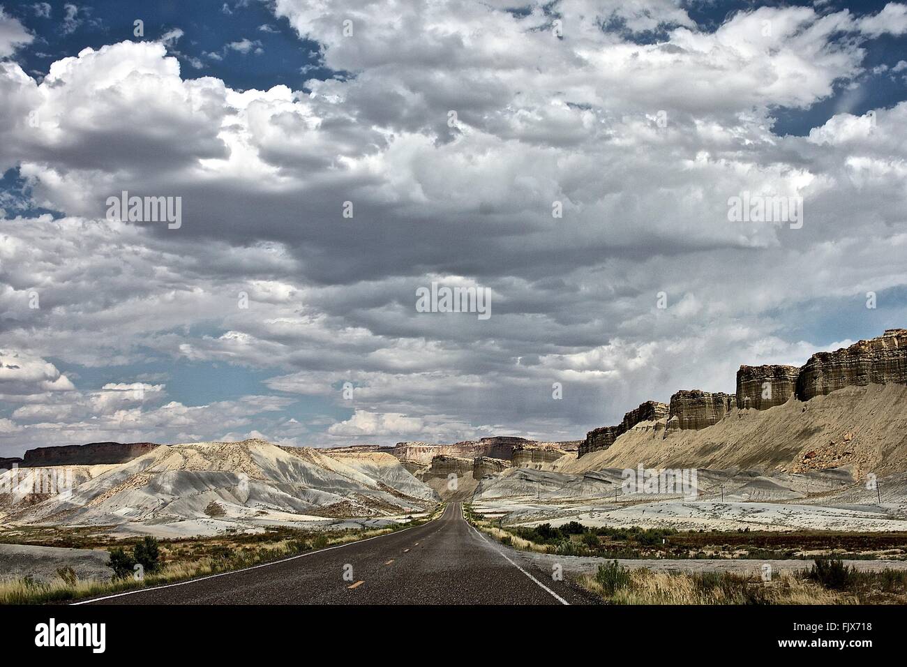 Road Amidst Mountains Against Cloudy Sky Stock Photo