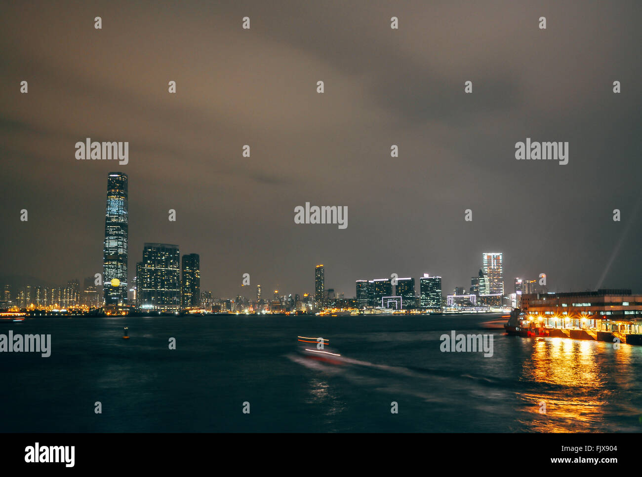 Scenic View Of Sea By Illuminated Cityscape Against Sky At Night Stock Photo