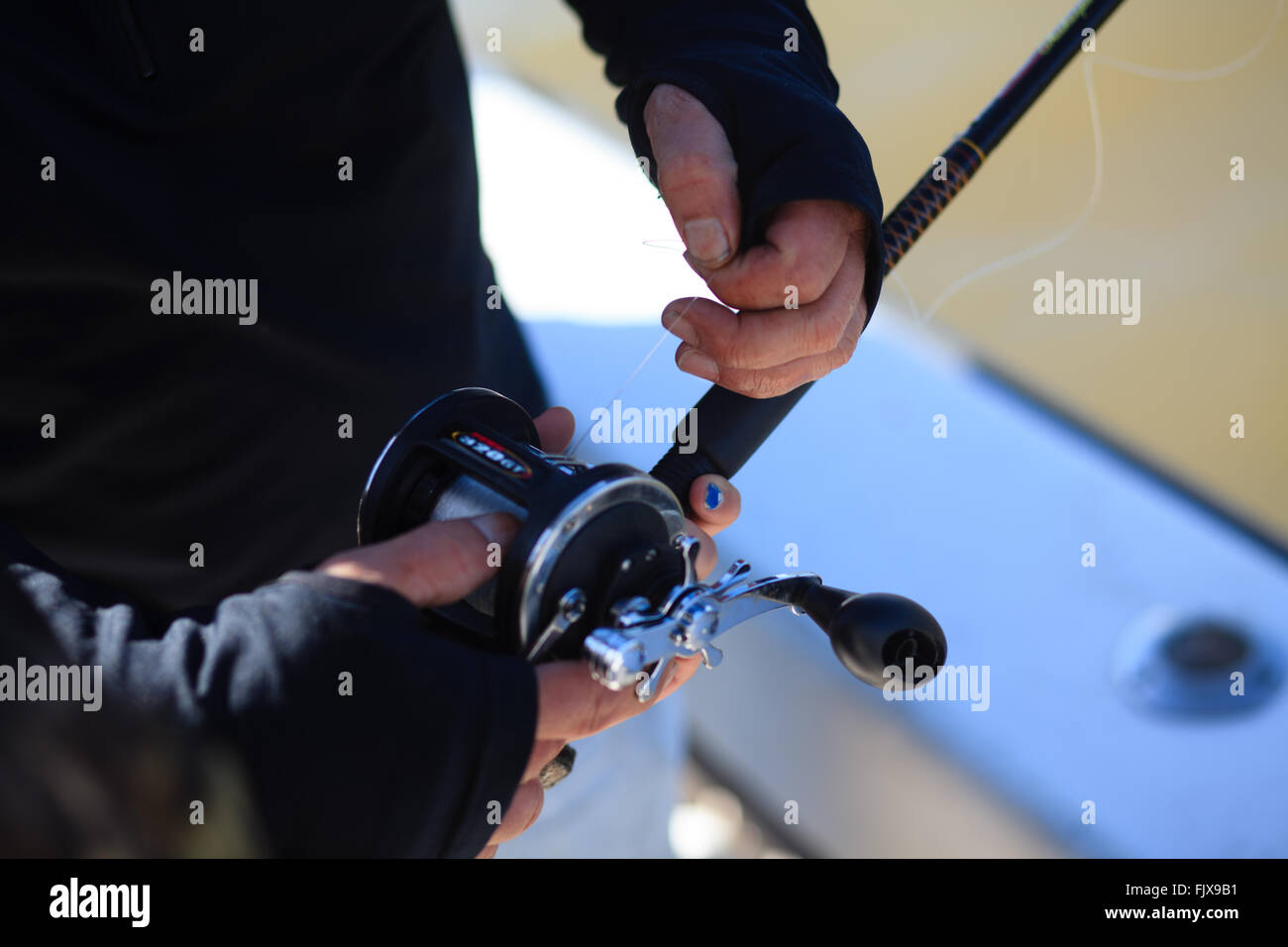 Fisherman pulling line off reel Stock Photo Alamy