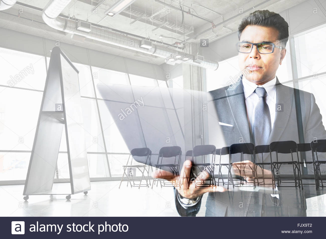 Digital composite businessman working at laptop conference room Stock