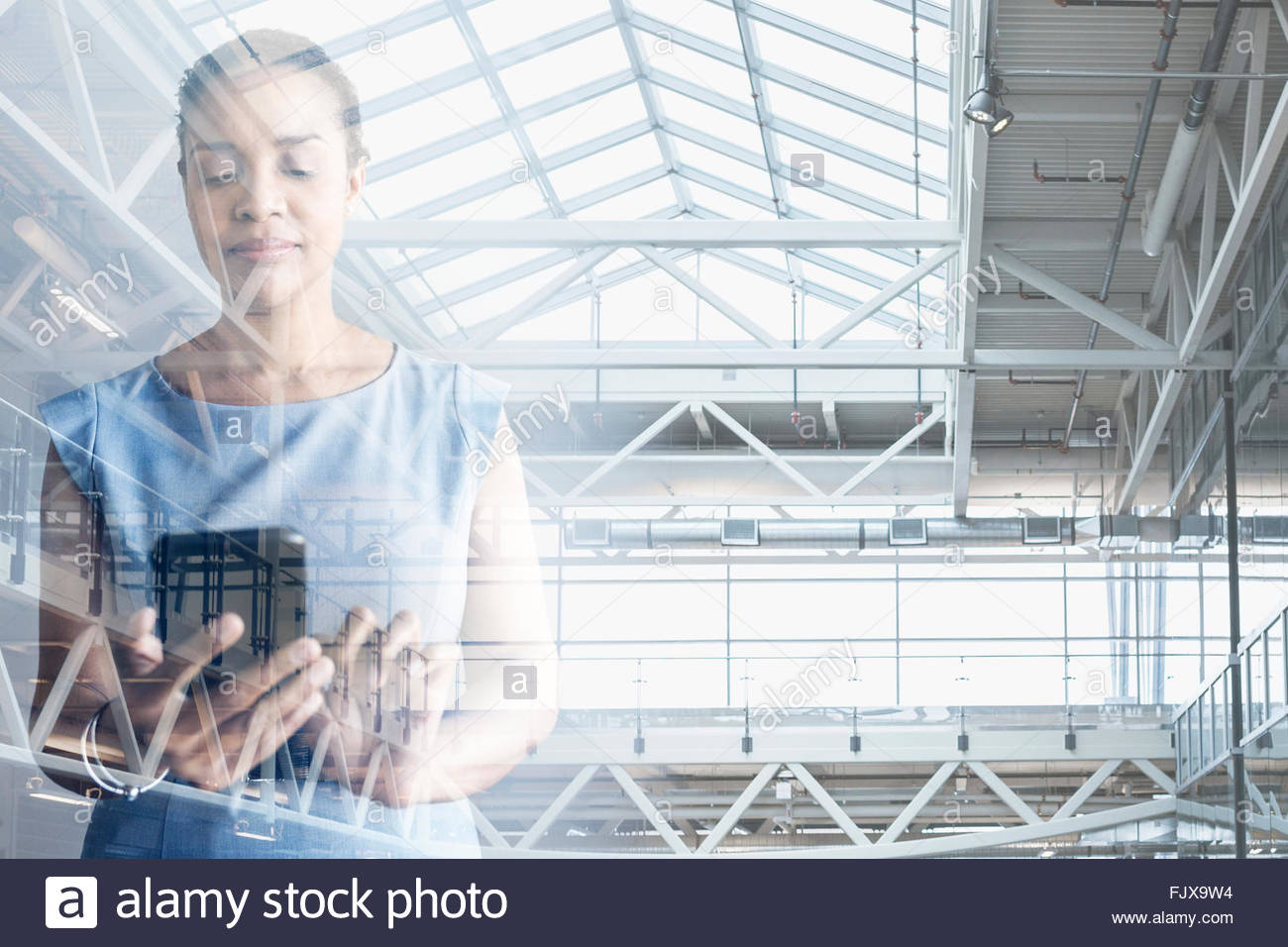 Digital composite businesswoman using cell phone modern atrium Stock ...